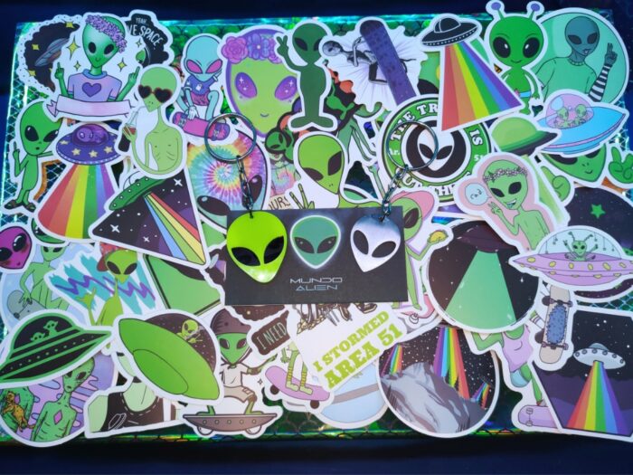 Paquete de 50 stickers y 2 llaveros Alien de Mundo Alien, con diseños únicos y resistentes al agua, ideales para los aficionados a la cultura extraterrestre.